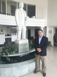 Garland, who opens discussions of Greene County’s advantages by talking about the county’s history, poses with a statue of President Andrew Johnson.